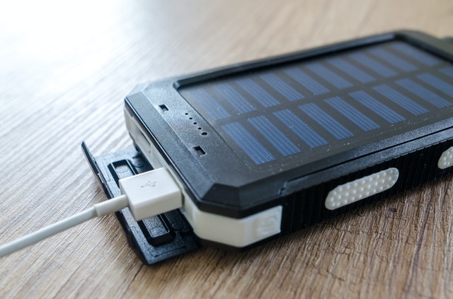 Czarny Powerbank solarny z wpiętym białym kablem USB
