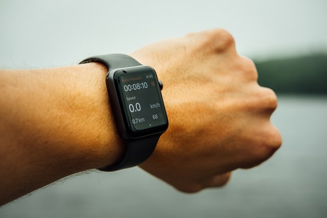 Czarny smartwatch na ręce z zaciśniętą w pięść dłonią