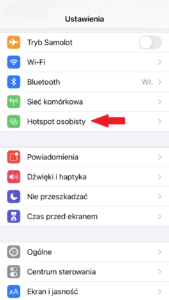 Screen z menu telefonu iPhone z czerwoną strzałką na opcji "Hotspot osobisty"