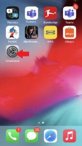 Screen z telefonu iPhone z czerwoną strzałką wskazującą Ustawienia