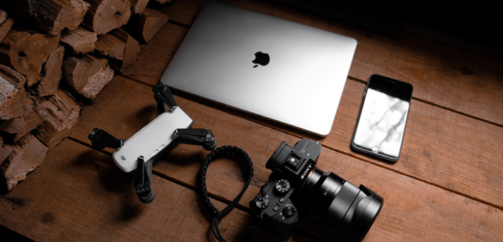 Dron do fotografowania obok aparatu telefonu i laptopa