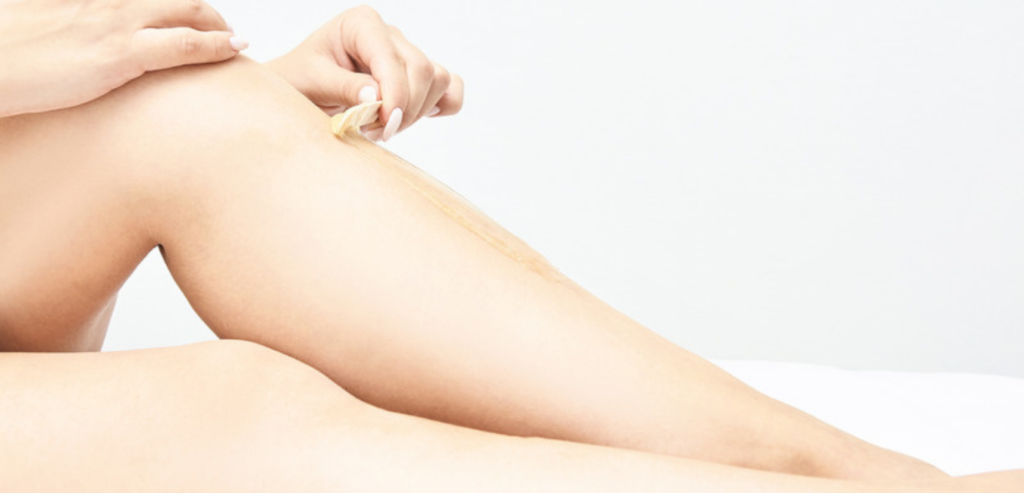 Kobieta nakłada wosk do depilacji na nogi