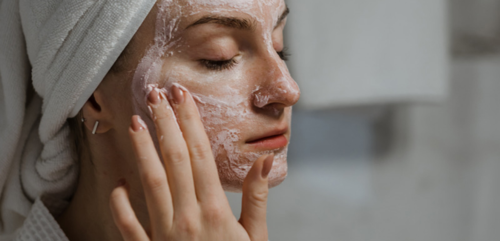 Kobieta oczyszcza skórę i wykonuje peeling