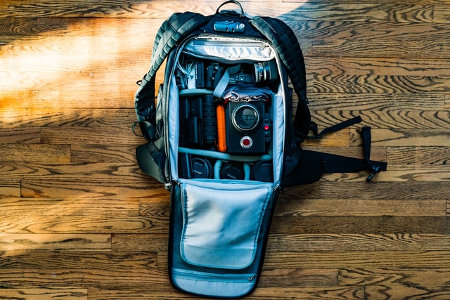 Sposób dostępu do aparatu fotograficznego - otwarty plecak z aparatem i akcesoriami